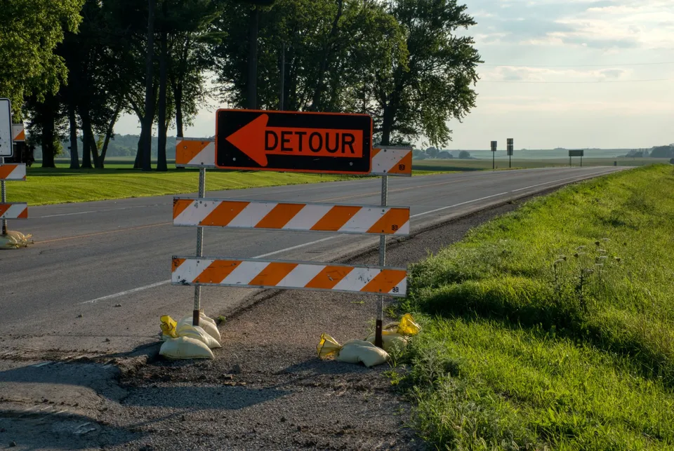 Roadside detour sign with arrow in rural Plainview, MN, under clear skies. Perfect for travel and road maintenance themes.